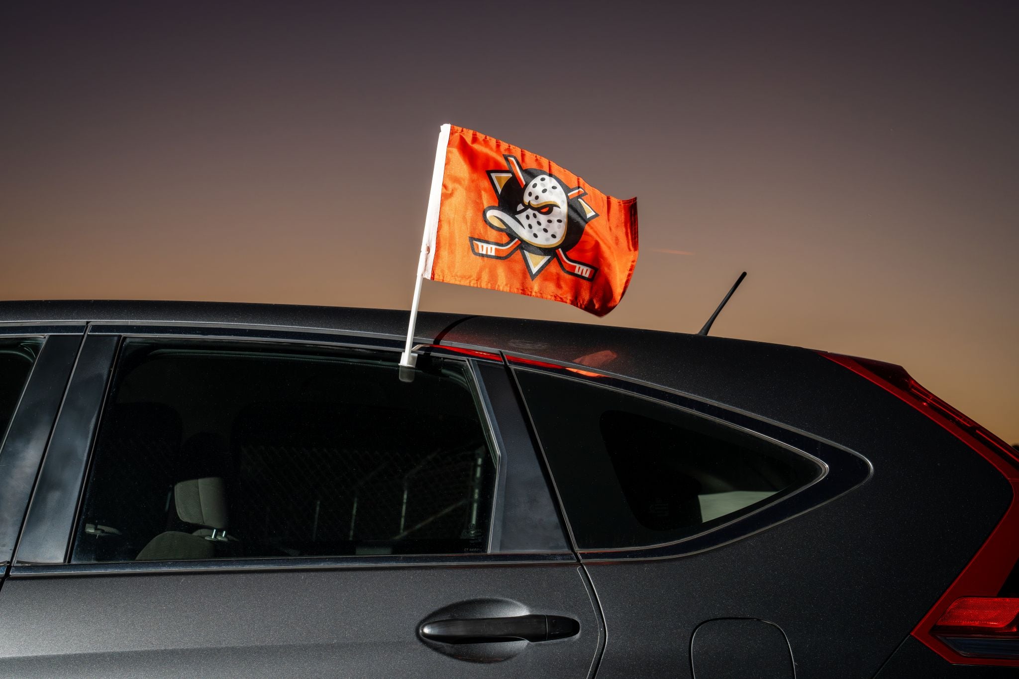 Anaheim Ducks orange car flag at sunset on the back window of a Honda CRV