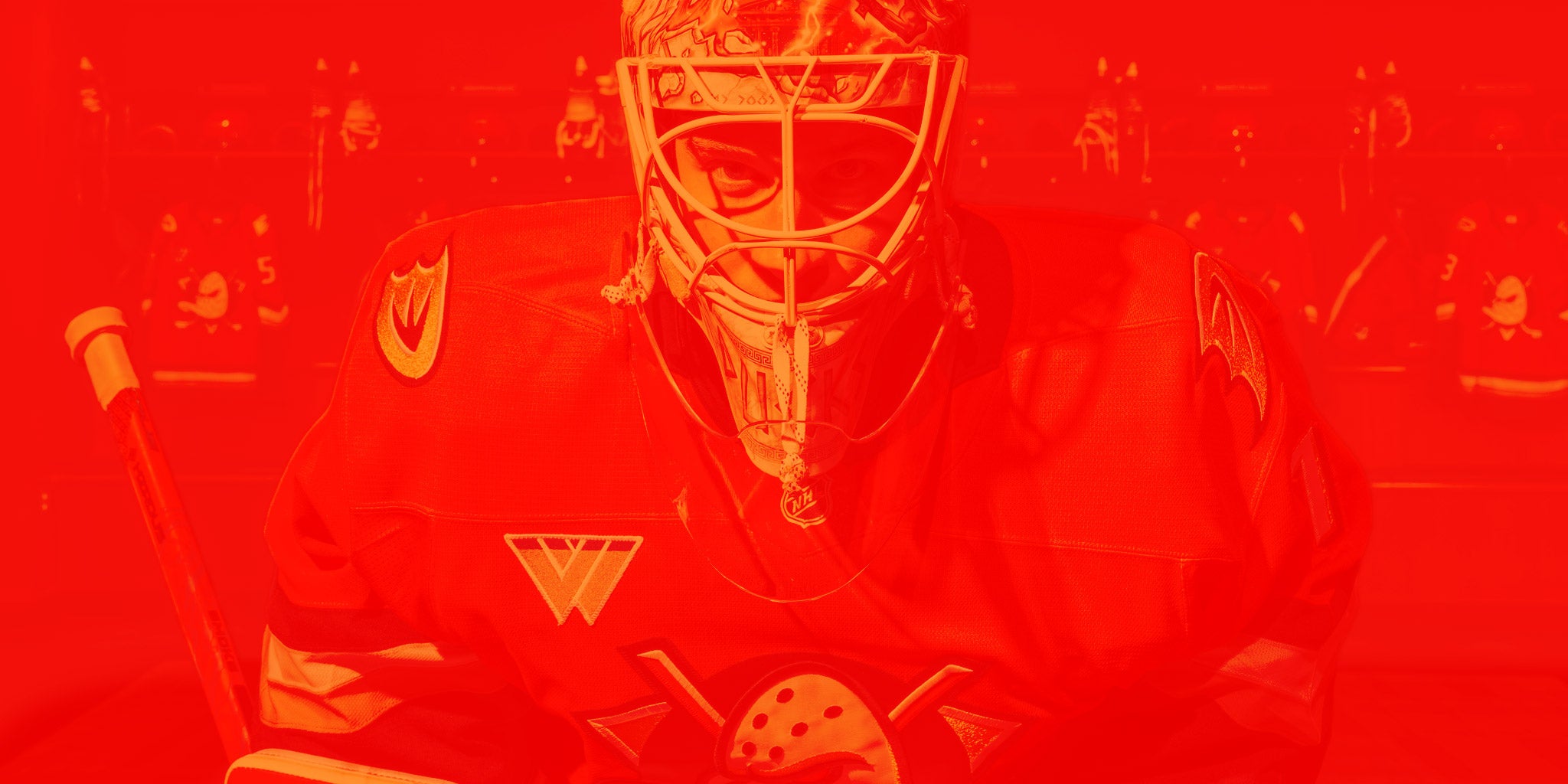 Anaheim Ducks goaltender Lukas Dostal (#1) poses in the Honda Center locker room with jerseys and other gear.