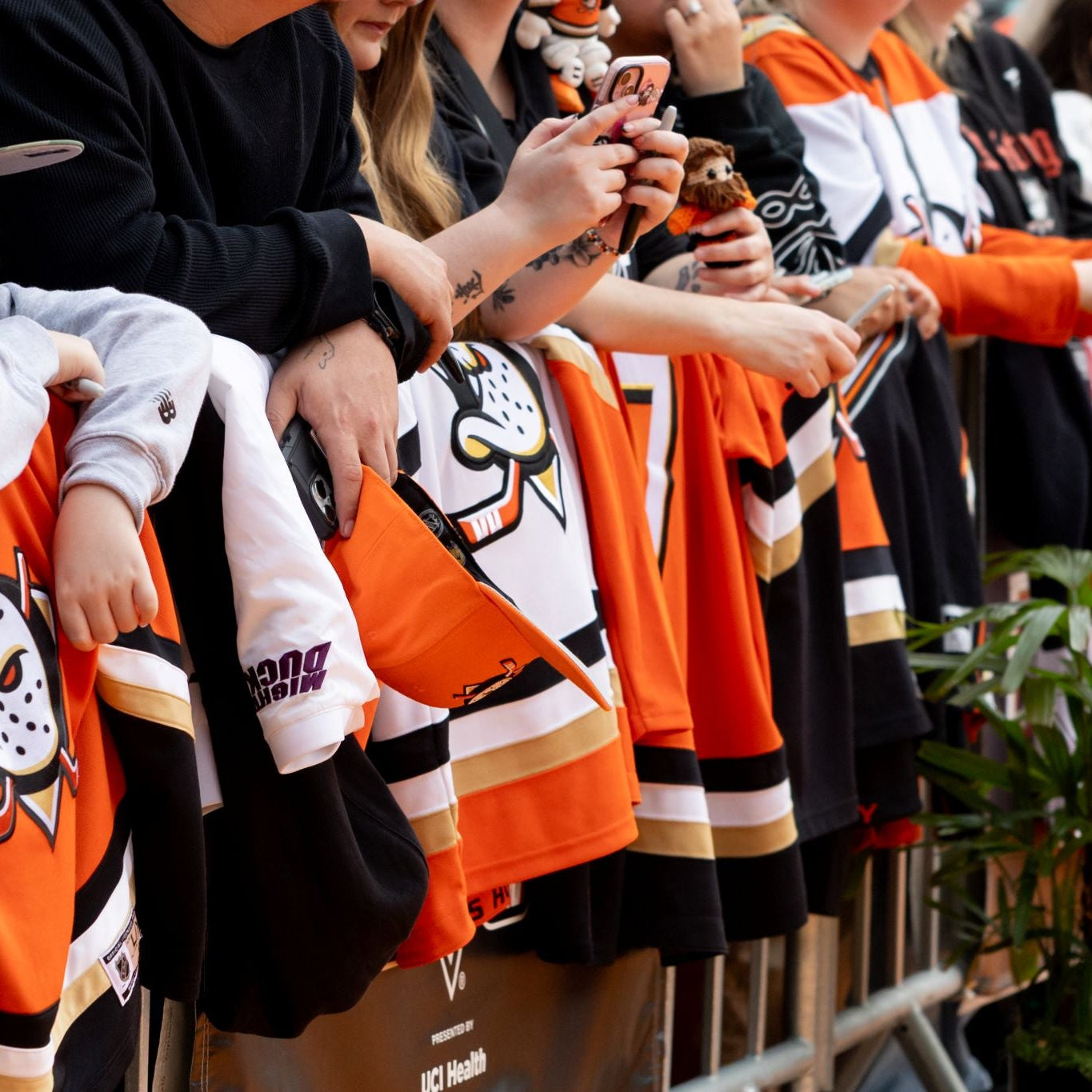 Fans decked out in new merchandise wait for autographs at the 2025 Anaheim Ducks home opener Orange Carpet.
